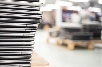 up close stack of laptops awaiting repairs